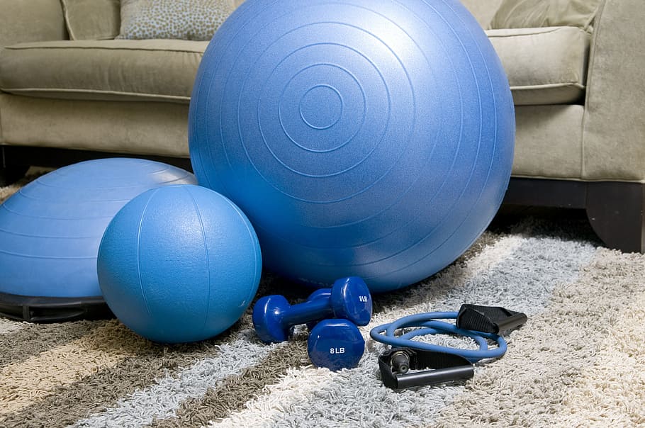 assorted exercise equipment on fabric rug, home fitness equipment