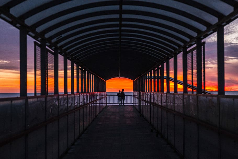 silhouette photo of persons on foot bridge, silhouette photo of two persons on metal made hallway HD wallpaper