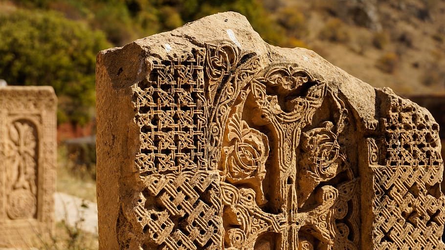 closeup photo of gray concrete wall, cross-stone, carving, khachkar