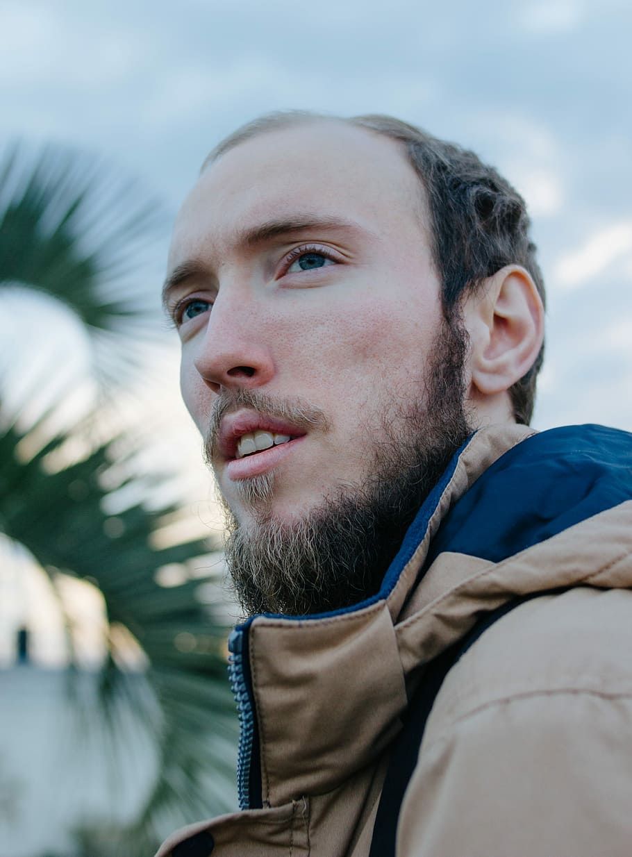 man wearing blue jacket looking in distance, tilt-shift lens portrait photography of man HD wallpaper