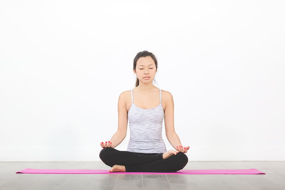 woman in gray spaghetti strap top sitting on pink yoga mat while meditating, HD wallpaper