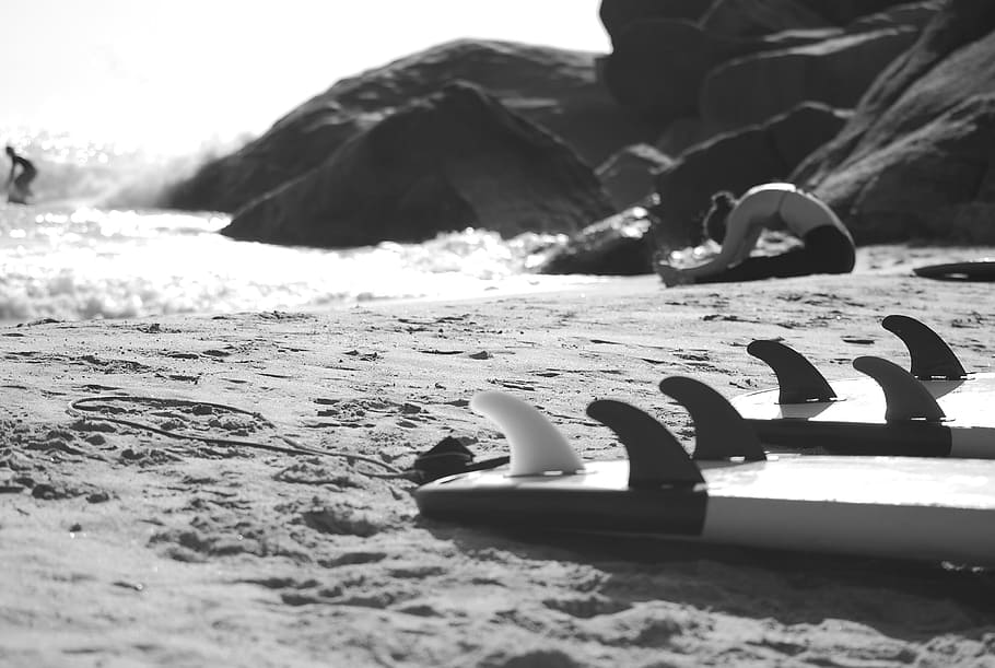 Grayscale Photo of Woman Sitting on Beach Near Rock Formation, HD wallpaper