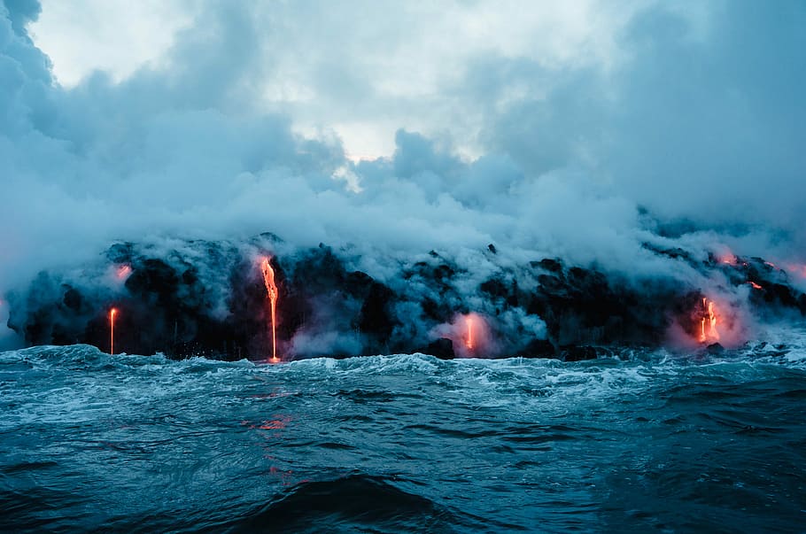 lava dripping to ocean, erupting volcano near body of water, steam