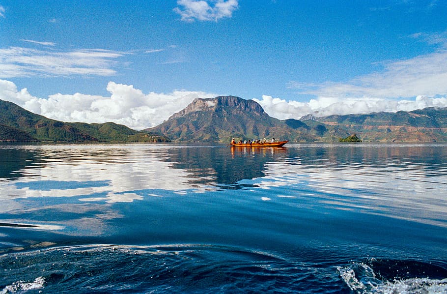 group of people riding on boat at body of water, landscape photography of body of water near mountain HD wallpaper