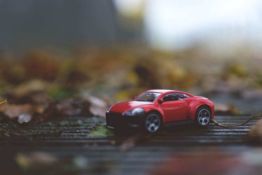 selective focus photography of red die cast toy car, red coupe scale model on floor HD wallpaper