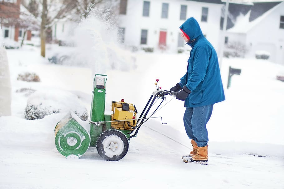 man wearing blue hooded jacket holding green snow thrower, snow blower HD wallpaper