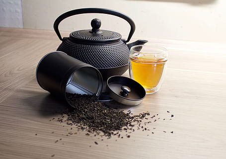 black kettle beside glass cup on top of brown wooden surface HD wallpaper