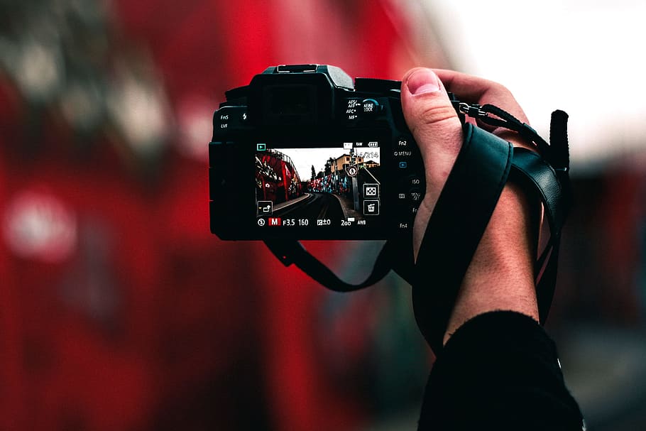 black DSLR camera capturing road, selective focus photography of person holding DSLR focusing on street image, HD wallpaper