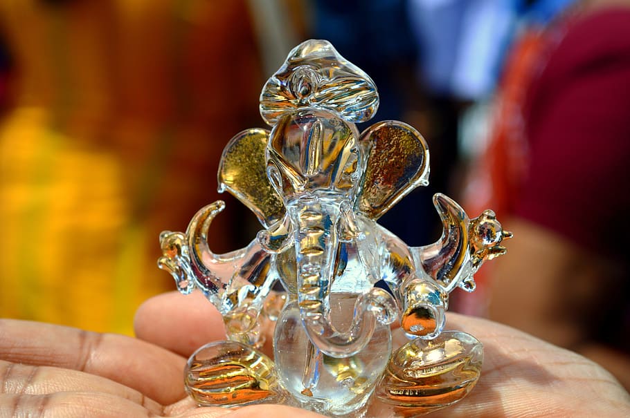 person holding clear glass table decor, ganesh, hinduism, figurine