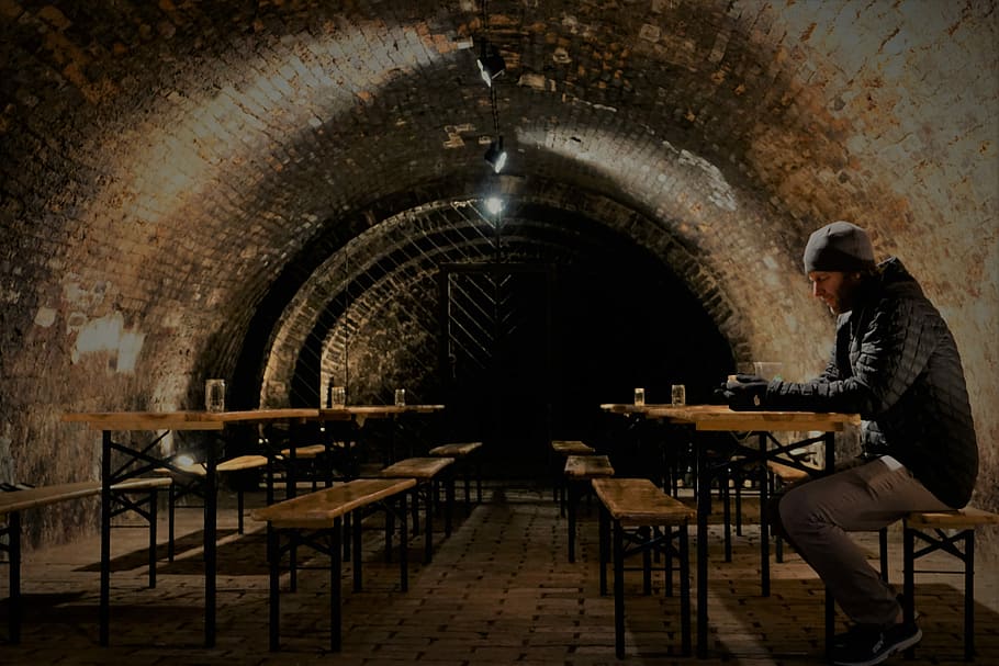 man sitting on bench holding cup, tunnel, brickwork, industrial HD wallpaper