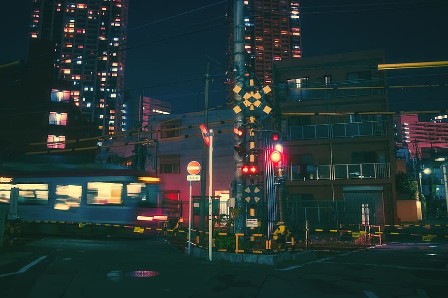 blue train passing through buildings at nighttime, japan, osaka
