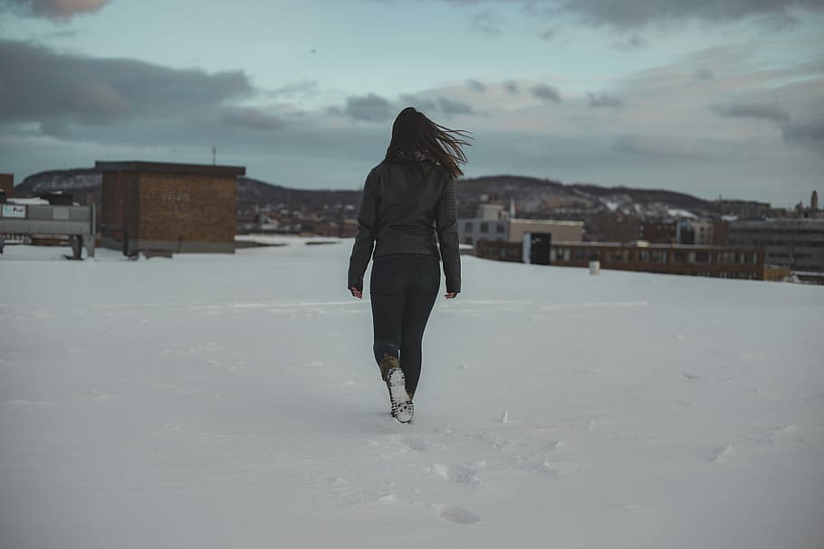 woman walking through brown building, woman walking near snow covered field during daytime, HD wallpaper