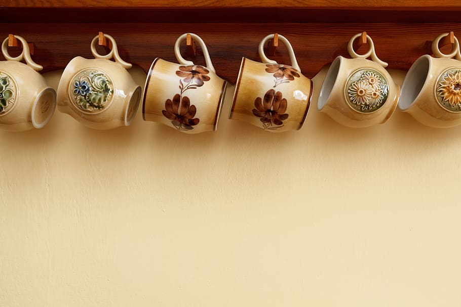 six assorted-color floral ceramic teacups hanged on brown wooden wall-mounted shelf with hooks, HD wallpaper