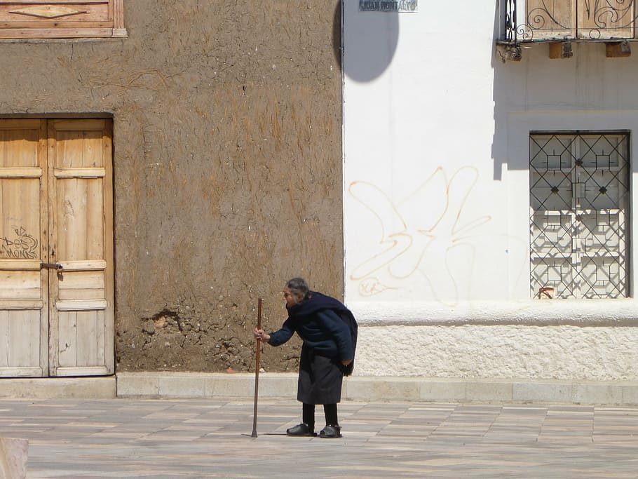 person walking on street while holding walking cane, cuenca HD wallpaper