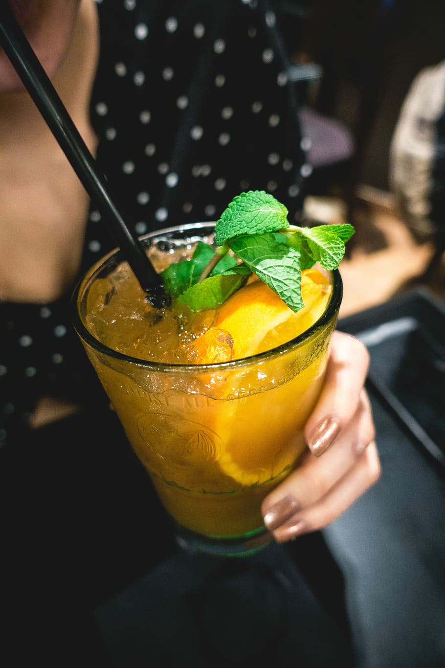 Orange juice drink with mint, bar, close up, hands, cocktail