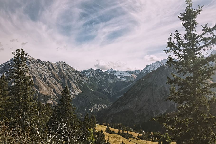 ice capped fault-block mountain under cumulus clouds nature photography, green pine trees near the mountain HD wallpaper
