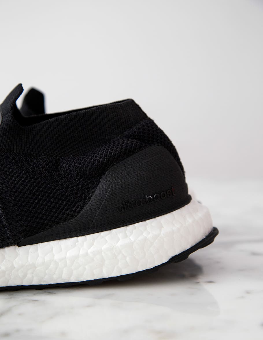 black and white adidas UltraBOOST shoe, unpaired black adidas Ultra Boost shoe