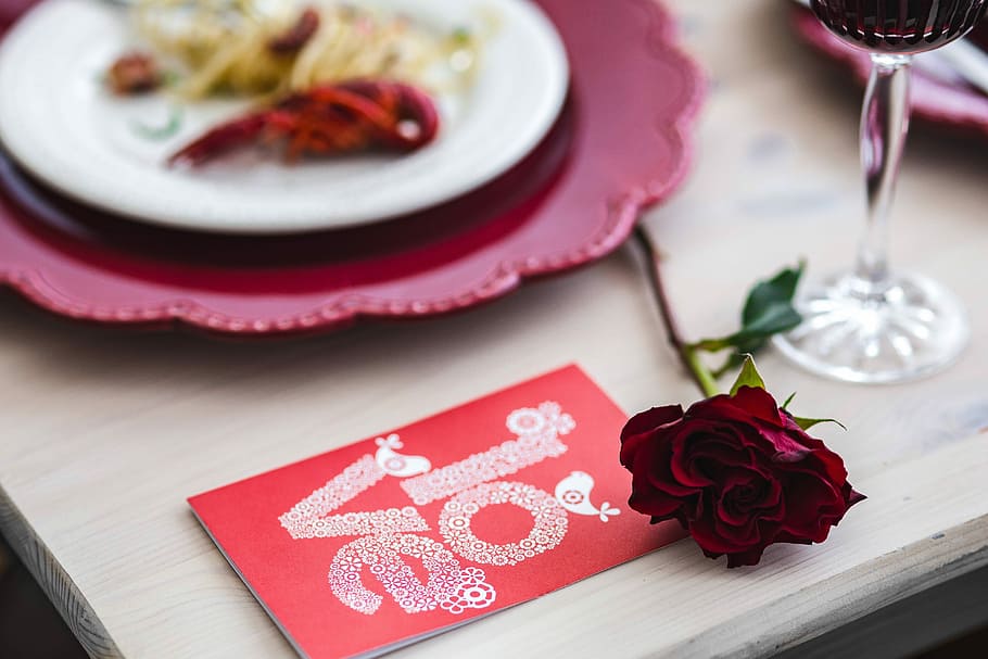 Fancy dinner with seafood pasta, crayfish and red wine by the table decorated with roses HD wallpaper