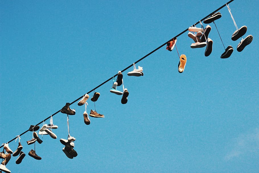 low angle photo of footwear lot, worm's eye view photography of shoes hanged on wire on top HD wallpaper