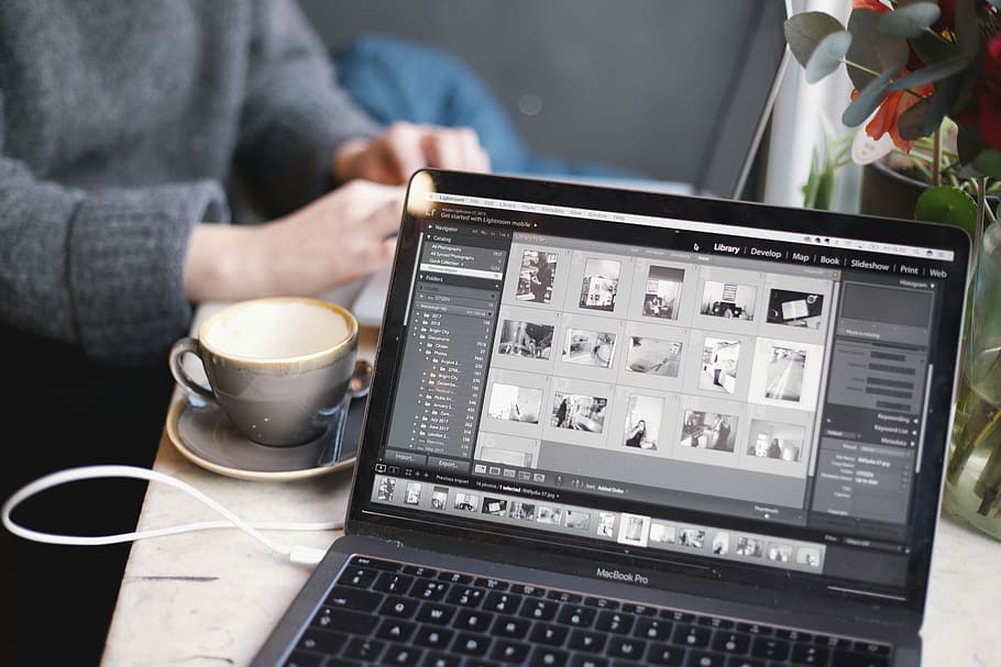 MacBook Pro beside white cup, MacBook Pro near on coffee cup HD wallpaper