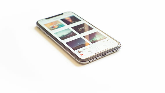 silver iPhone X on Apple Music menu, turned on silver iPhone X on white surface HD wallpaper