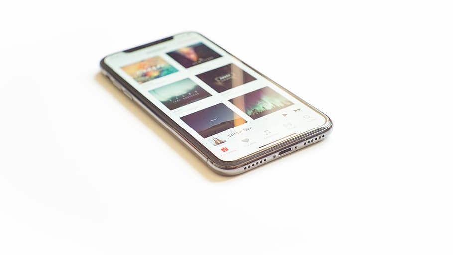 silver iPhone X on Apple Music menu, turned on silver iPhone X on white surface HD wallpaper