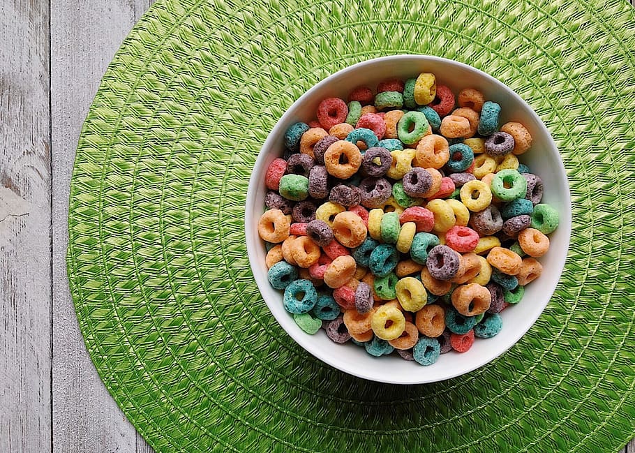 bowl of cereals on top of green place mat, fruit loops, colorful