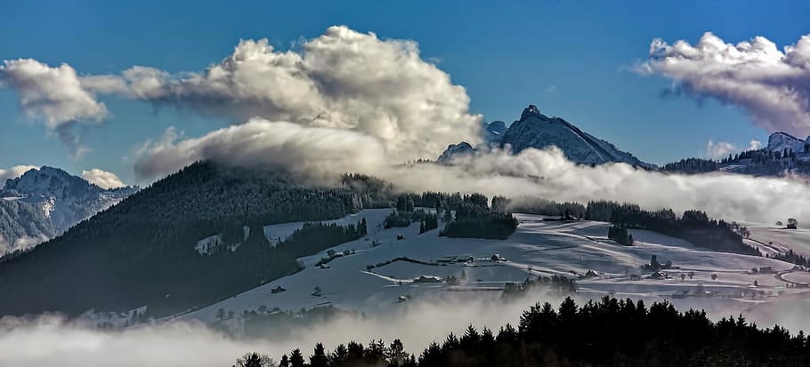 mountain covered by white clouds, person showing mounting under cloudy sky HD wallpaper