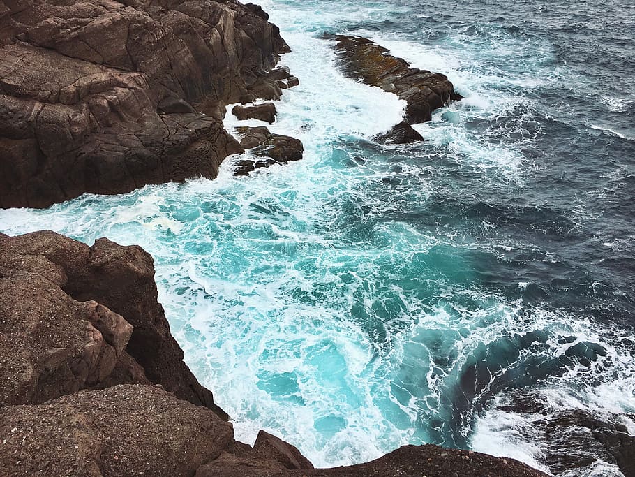 aerial photography of brown cliff near body of water during daytime, body of water and rock formation HD wallpaper