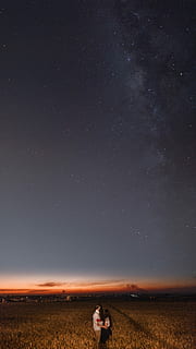 man and woman standing near grass field at nighttime, couple standing on field under starry skies HD wallpaper