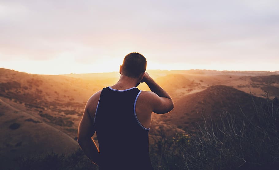 man in black tank top standing on hill during golden hour, outdoors HD wallpaper