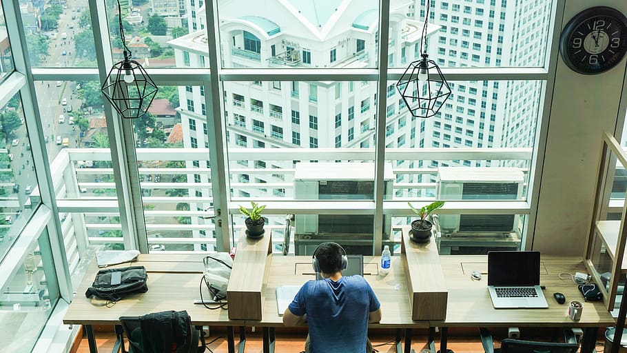 man in blue top using laptop computer, man wearing headphone inside the room HD wallpaper