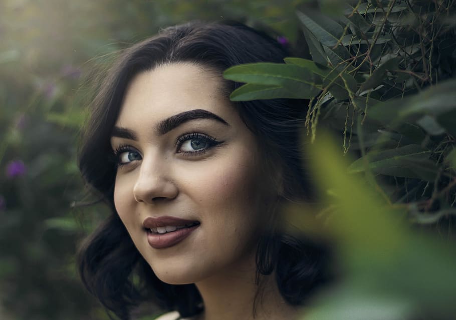 smiling woman wearing red lipstick near green leaf plant, person HD wallpaper