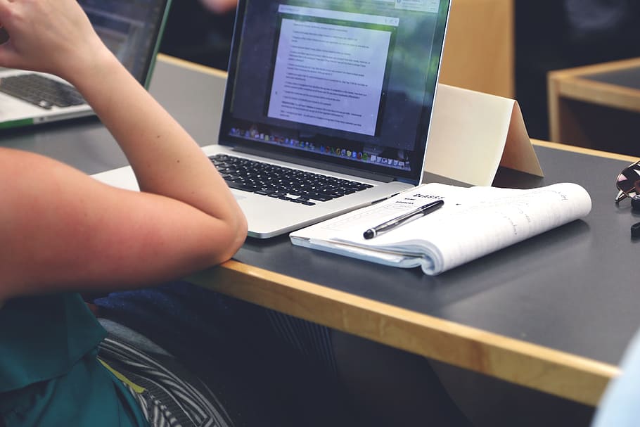 person sitting in front of turned on MacBook Pro, startup, start-up HD wallpaper