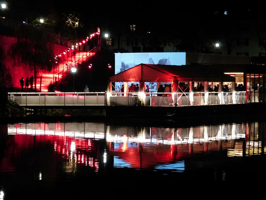 group of people gathering beside body of water during night time HD wallpaper