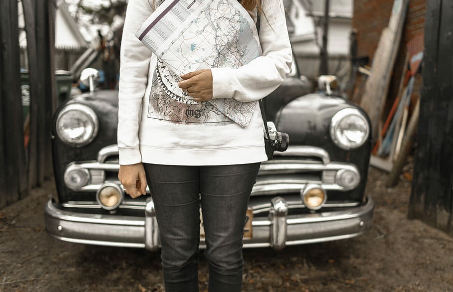 Download A Woman In A Black Jacket Standing In Front Of A Car Wallpaper