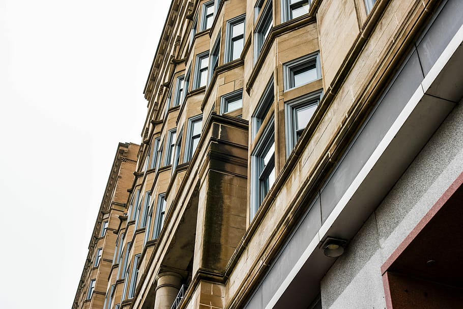 low angle photo of brown concrete building, beige high-rise building HD wallpaper