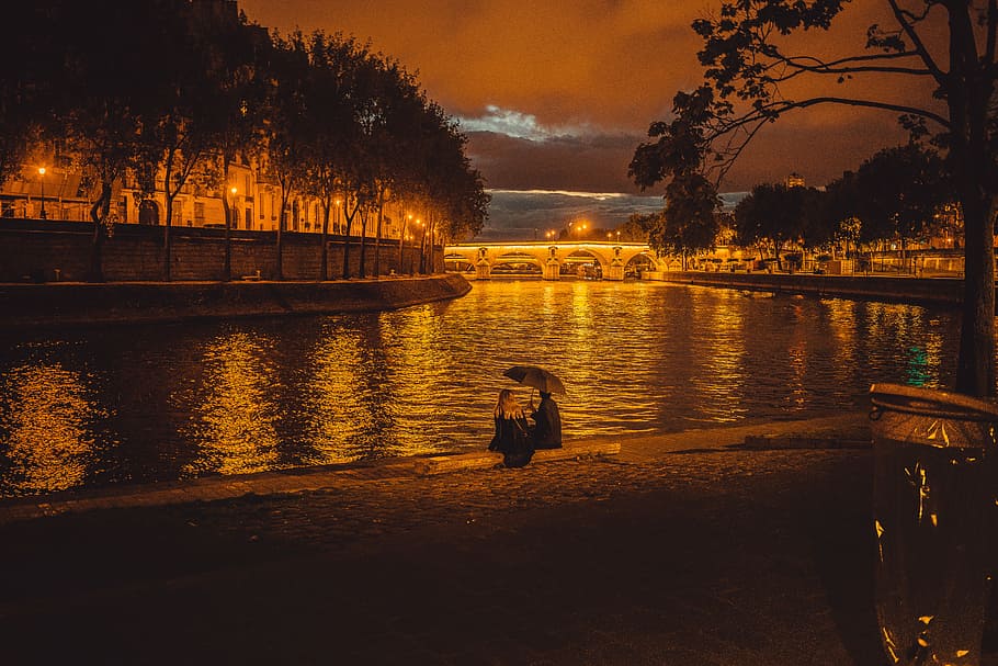 person sitting near pond, man and woman sitting beside grand canal during night time HD wallpaper