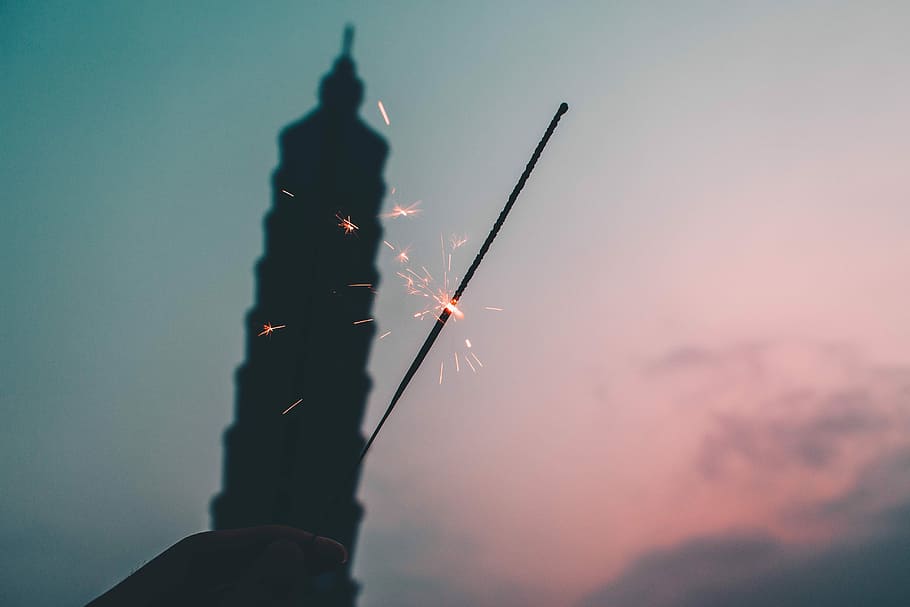 silhouette of person holding stick, steel wool photography of tower HD wallpaper