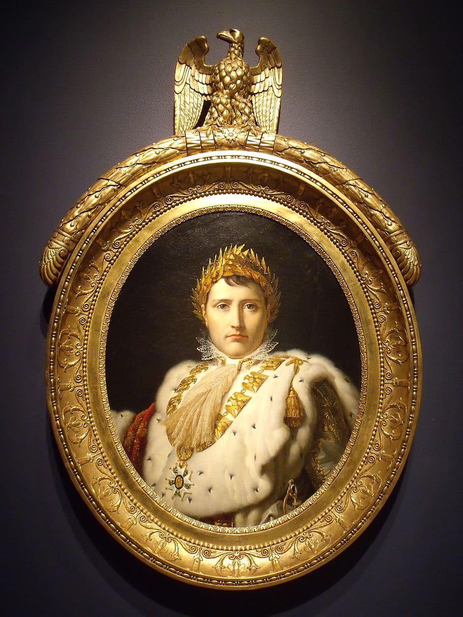 round gold-colored framed portrait of man wearing gold crown