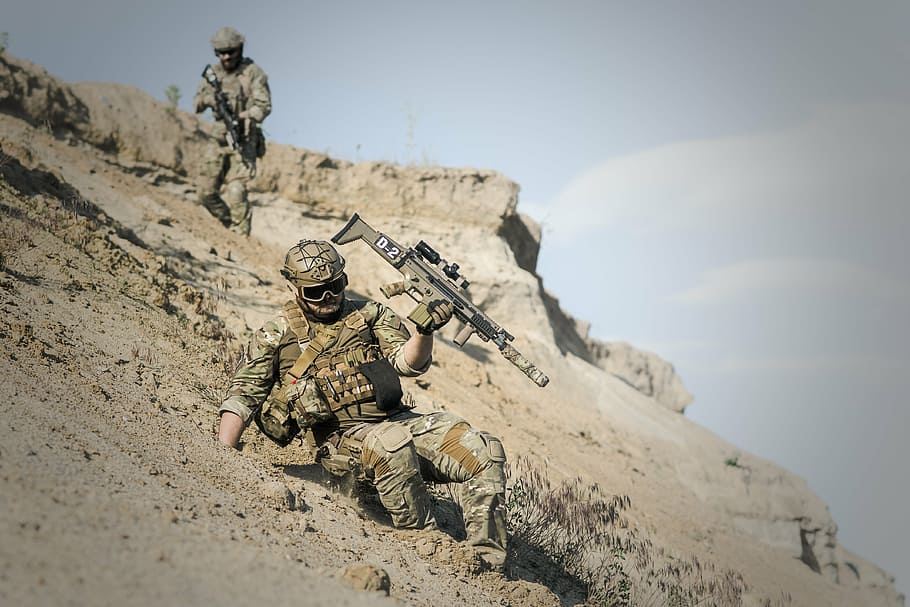 soldier in realistic camouflage suit holding assault rifle sliding downhill HD wallpaper
