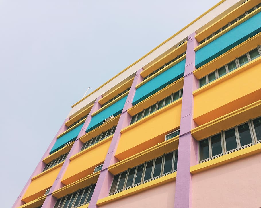 low angle photography of colorful building, orange high-rise concrete building HD wallpaper