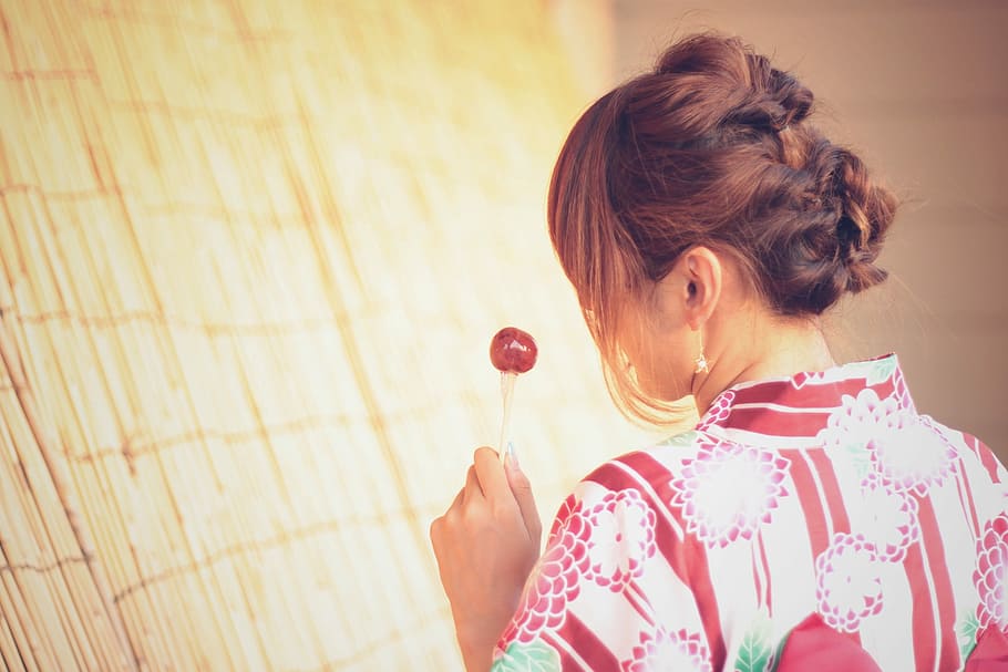 woman in white and brown floral dress holding lollipop, people HD wallpaper