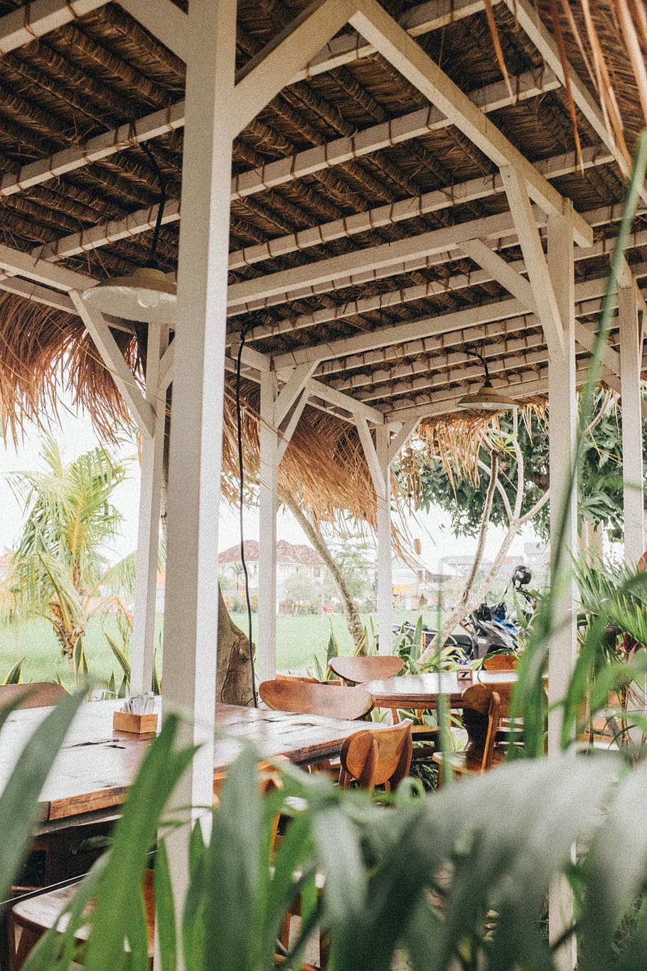 brown wooden tables and chairs, white and brown wooden building with brown wooden dining set during daytime HD wallpaper