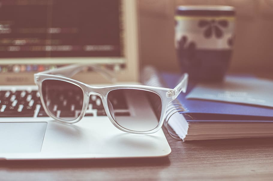 selective focus photograph of acrylic framed sunglasses on MacBook Air near notebook HD wallpaper
