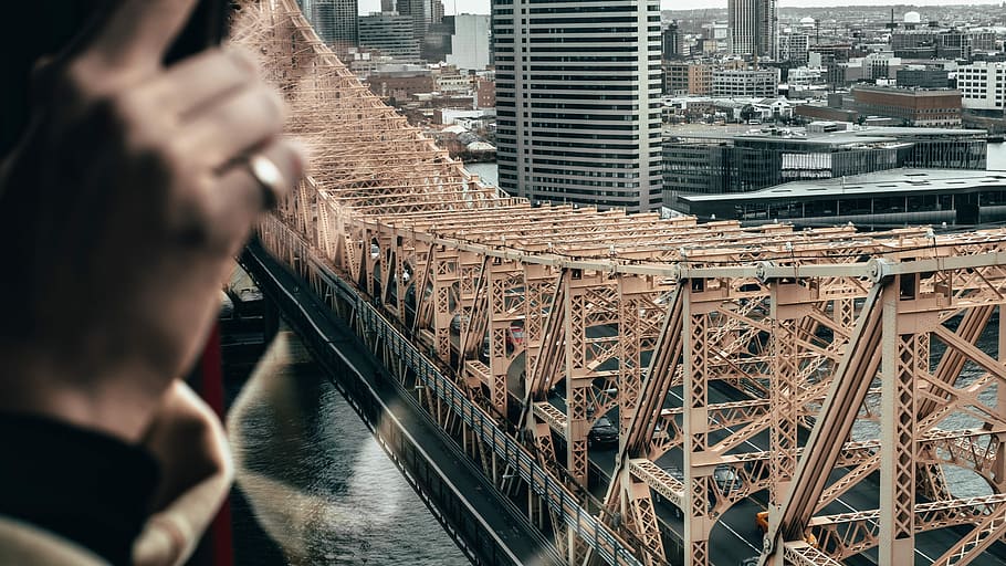 black and brown concrete bridge near city buildings, aerial view of gray steel bridge HD wallpaper