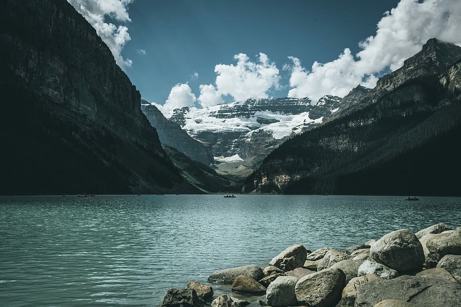 landscape photography of body of water between mountains, snow covered mountain, body of water and blue sky HD wallpaper