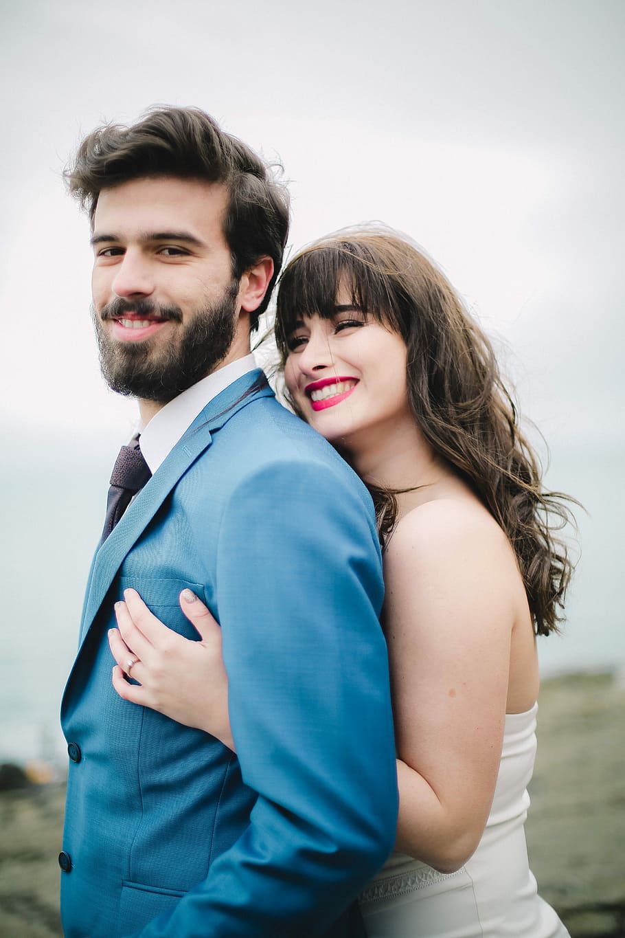 Gül Kurtaran, selective focus photo of groom and bride smiling while standing during daytime