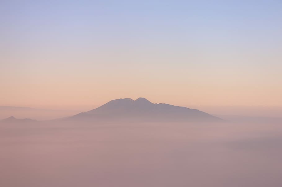 black mountain under blue sky at daytime, mountain range covered by clouds HD wallpaper