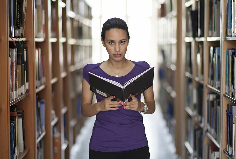 woman in purple top holding book in library, model, women's, exposure